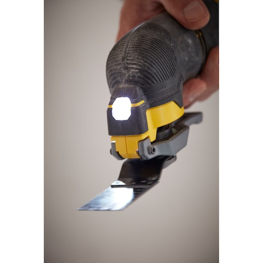 STANLEY SFMCE500B oscillating multi-tool close-up with LED light on, showing blade attachment in use.