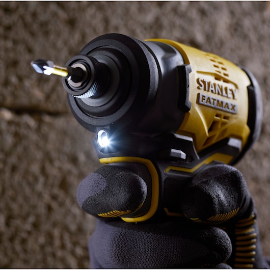 STANLEY SFMCF810B impact driver close-up, yellow and black, gloved hand, LED light illuminated.