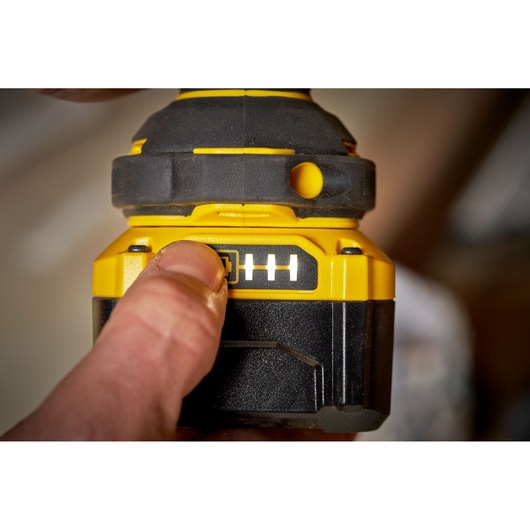 STANLEY SFMCF920B battery indicator on cordless tool, close-up view with finger pressing button.