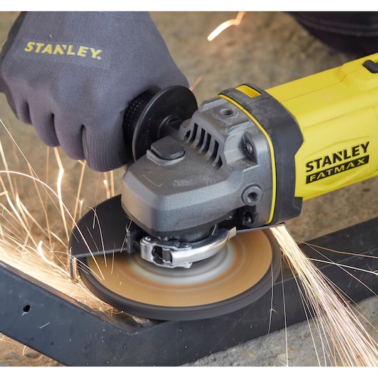 STANLEY SFMCG400M1K angle grinder in use, emitting sparks while grinding metal, close-up view.