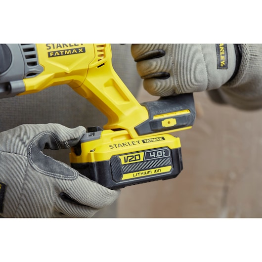 Stanley SFMCH900M12 FATMAX drill with V20 4.0Ah lithium ion battery held by gloved hands.