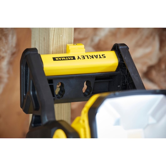 STANLEY SFMCL030B work light mounted on wooden post, close-up angle, yellow and black body.