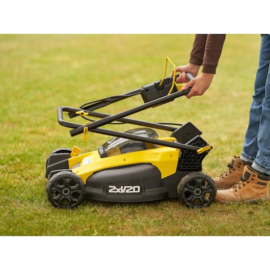 STANLEY SFMCMW2651M lawn mower side view, folded handle, yellow and black design, on grass.