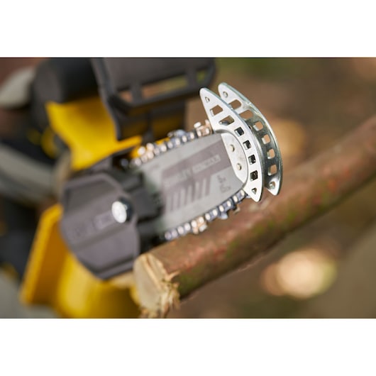 STANLEY SFMCPS415D1 chainsaw cutting a branch, close-up photo of blade and chain in action.