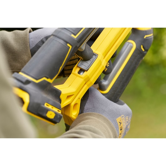 Stanley SFMCPS515M1 cordless pruning saw close-up showing handle and control switch outdoors.