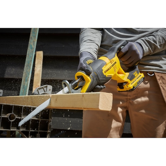 STANLEY SFMCS300D1K cordless reciprocating saw cutting wood, close-up outdoor photography.