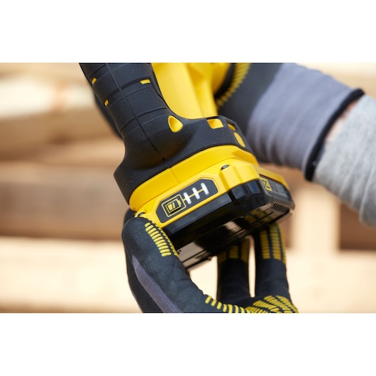 Photo of a STANLEY SFMCS300D2K cordless tool handle and battery in use, close-up view.