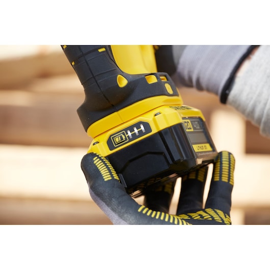 Photo of STANLEY SFMCS300M1K power tool battery pack close-up held by gloved hand.
