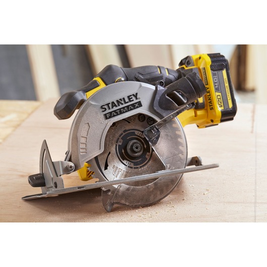 STANLEY SFMCS500B cordless circular saw, side angle, yellow and black, in use on wood surface