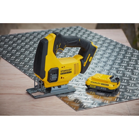 Photo of STANLEY SFMCS600D1K cordless jigsaw and battery on diamond plate sheet, product side angle.