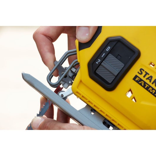 Photo of STANLEY SFMCS600D1K jigsaw, close-up of blade installation and yellow casing with mode selector.