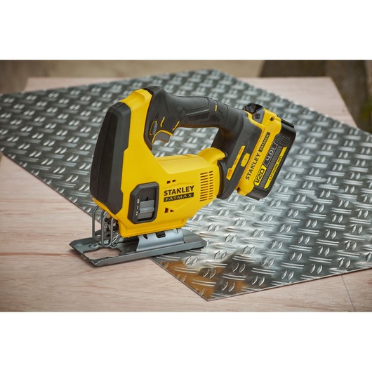 STANLEY SFMCS600M1K cordless jigsaw in yellow and black on metal sheet and wood surface.