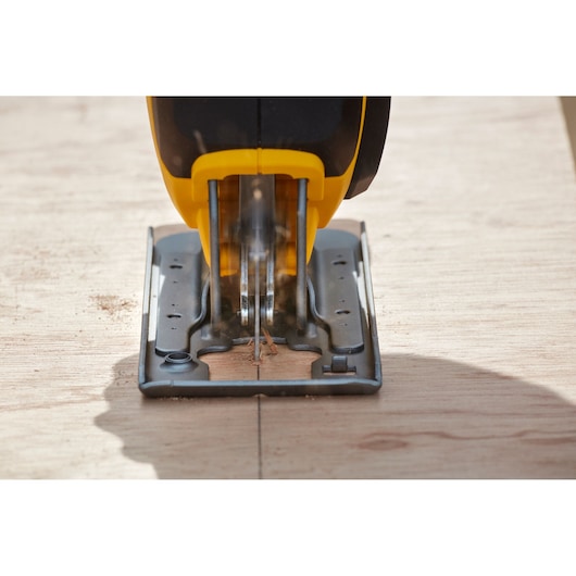 STANLEY SFMCS600M1K jigsaw cutting wood, close-up front angle, yellow and black tool visible.