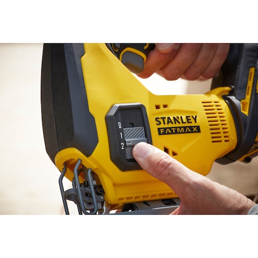 STANLEY SFMCS600M1K jigsaw control switch close-up showing hand adjusting speed.