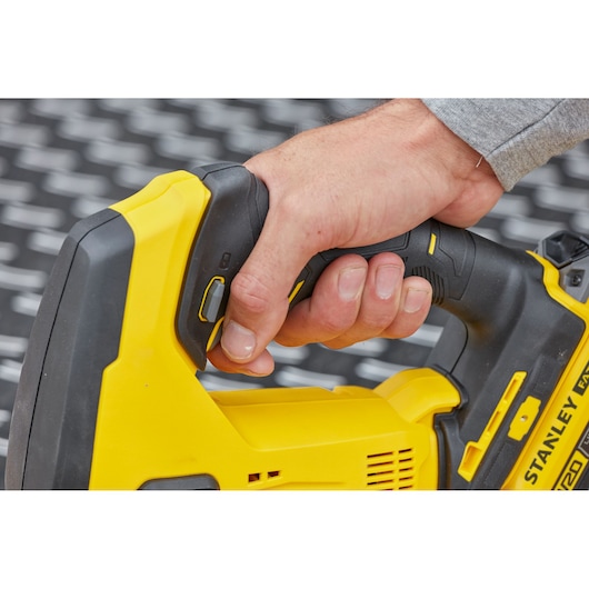 STANLEY SFMCS600M1K jigsaw close-up, yellow and black handle being gripped by a hand.