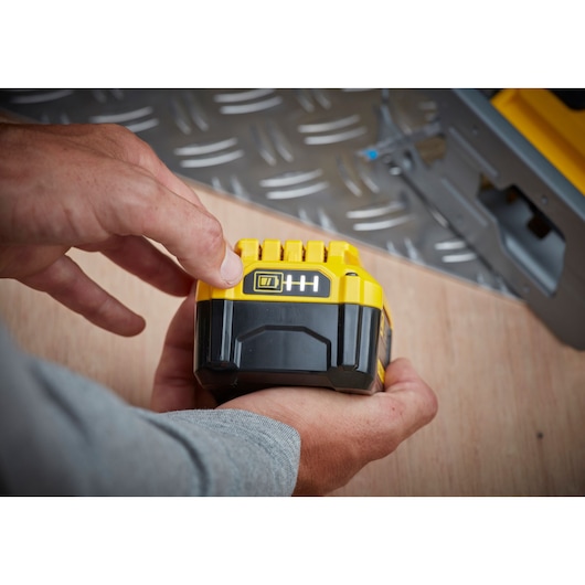 Photo of STANLEY SFMCS600M1K black and yellow power tool battery held in hand, close-up view.