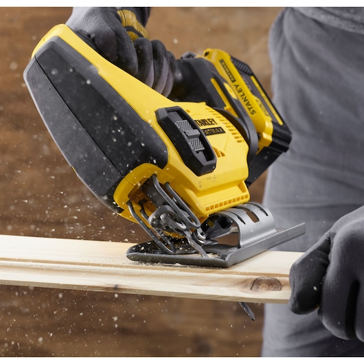 STANLEY SFMCS600M1K jigsaw cutting wood, close-up action shot, yellow and black tool.