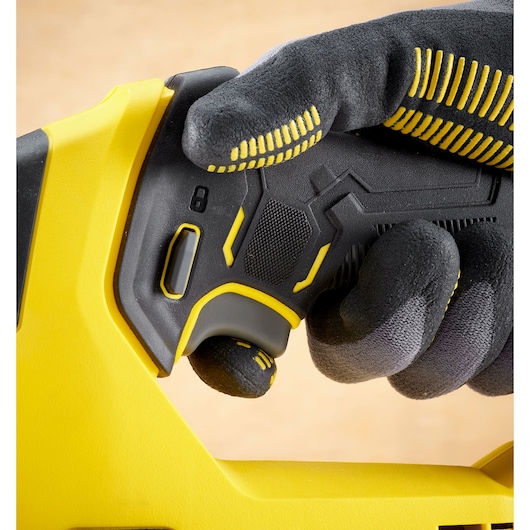 STANLEY SFMCS600M1K photography of yellow and black tool handle, close-up with gloved hand pressing trigger