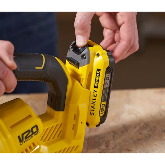 Close-up photo of STANLEY SFMCVH001B V20 Lithium Ion battery being inserted into yellow power tool.