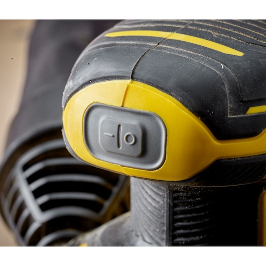 STANLEY SFMCW220B detail of yellow and black sander power switch, close-up photography.