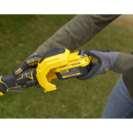 STANLEY SFMSTB930M power tool with V20 4.0Ah lithium-ion battery being held outdoors, close-up angle.