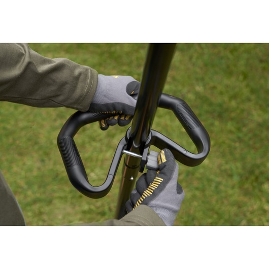 STANLEY SFMSTB930M lawn tool handle close-up, ergonomic black grip, shown outdoors.