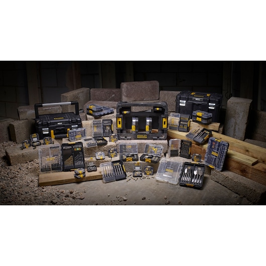 STANLEY STA88560 drill bit and accessory sets displayed with black toolboxes on construction site.