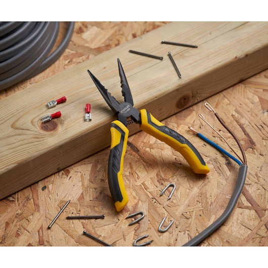STANLEY STHT0-74364 long nose pliers with yellow and black handles on a workbench with nails, wire, and connectors.
