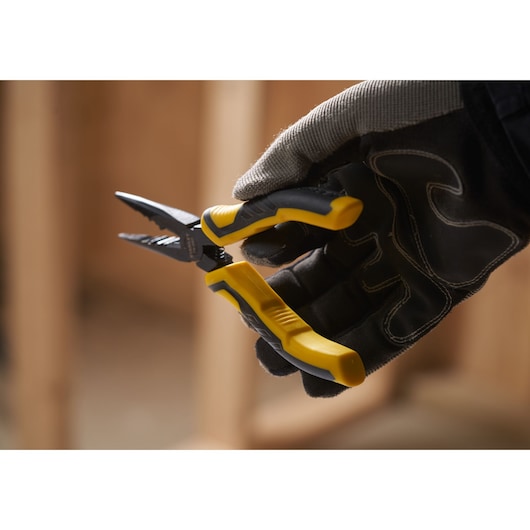 STANLEY STHT0-74364 wire stripper pliers with yellow handles held by a gloved hand.