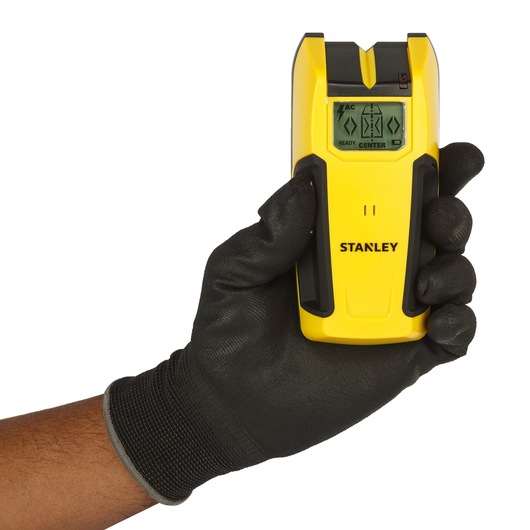 STANLEY STHT0-77406 yellow digital stud finder in gloved hand, front view, photography product.