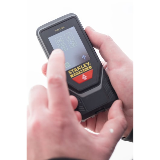 Photo of STANLEY STHT1-77142 laser distance measurer in use, user interacting with touch screen.