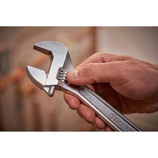 STANLEY STHT13122-0 adjustable wrench held in hand, silver finish, close-up photo.