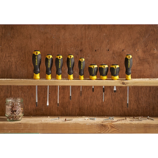 STANLEY STHT16148-0 screwdriver set with black and yellow handles on a wooden shelf, photography front view.