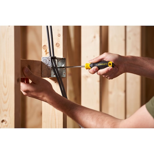 Photo of STANLEY STHT16155-0 screwdriver being used to install electrical box in wooden framing.