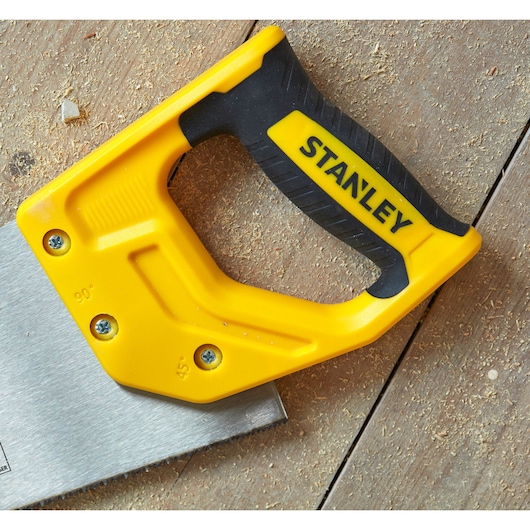 STANLEY STHT20372-1 saw with yellow and black handle, angled on wooden surface, close-up photography.