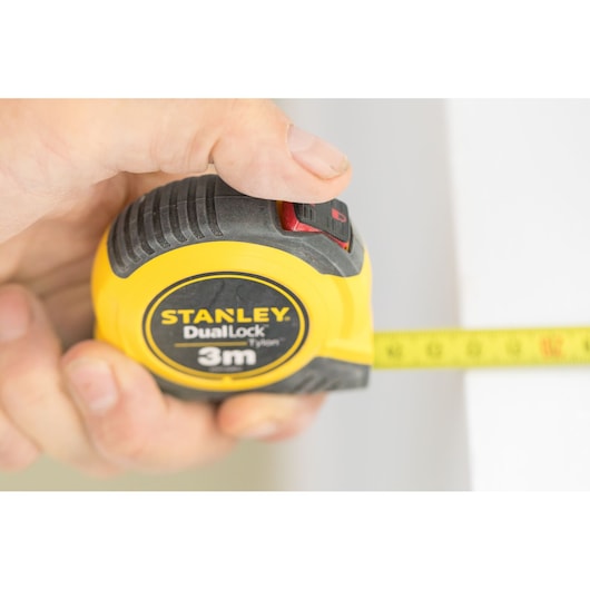 STANLEY STHT36806-0 tape measure with yellow and black casing, 3m length, shown in hand during measurement.