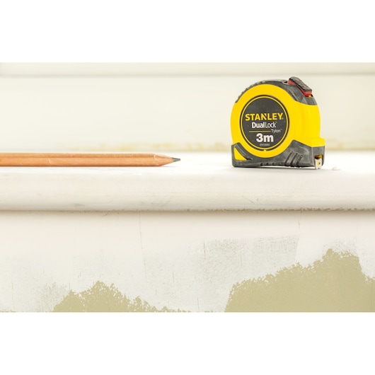 Photo of STANLEY STHT36806-0 tape measure next to pencil, front angle, 3m DualLock Tylon, yellow casing.