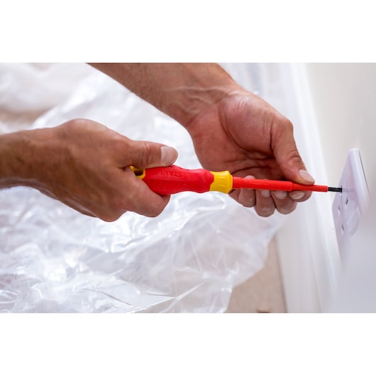 Photo of STANLEY STHT60030-0 insulated screwdriver in use installing a socket cover.