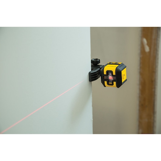 STANLEY STHT77498-1 laser level tool mounted on wall, projecting a bright red horizontal line.