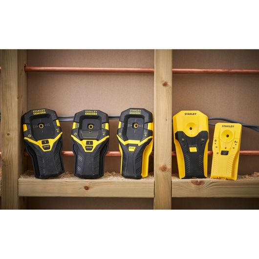 STANLEY STHT77588-0 stud finders, five black and yellow devices on wooden framing, front view.