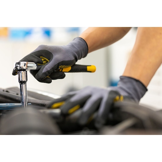 STANLEY STMT82665-0 ratchet being used with gloved hands in workshop, close-up photography.