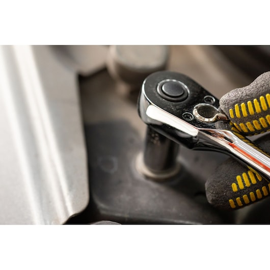 STANLEY STMT82666-0 ratchet tool in use, photography close-up with gloved hand turning bolt.