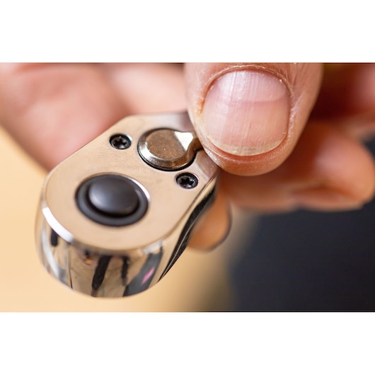 Photo of STANLEY STMT82670-0 ratchet tool head in hand, showing metal finish and push button.