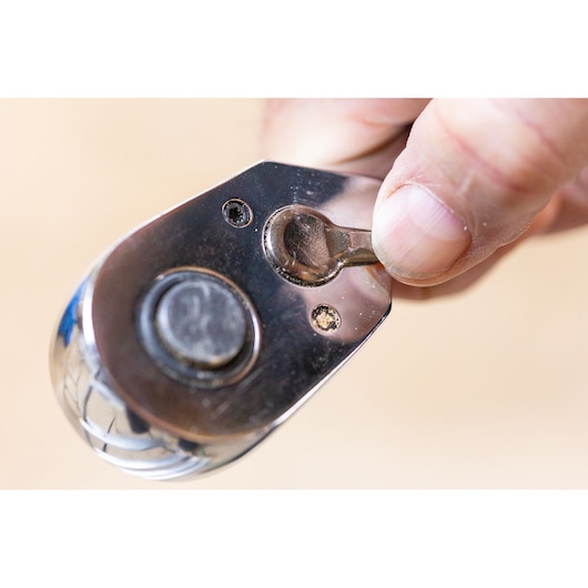 Photo of a hand adjusting the switch on a STANLEY STMT82831-1 ratchet tool close-up.