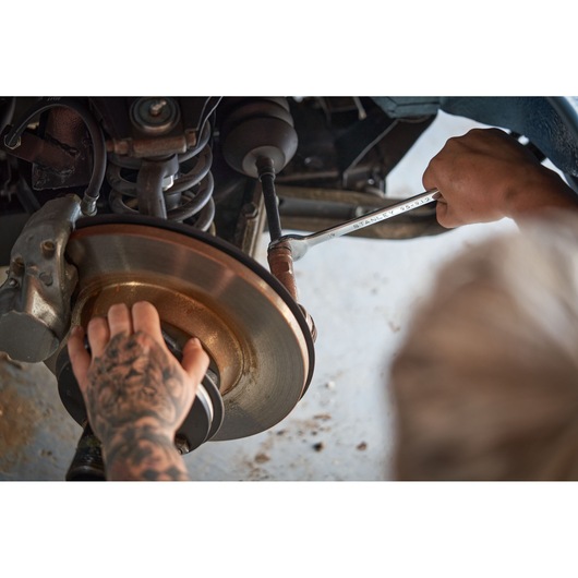Photo of STANLEY STMT82832-1 wrench in use on car brake assembly, part of 41-piece ratchet and wrench set.