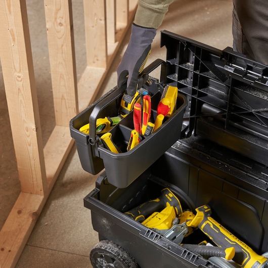 STANLEY STST1-70715 tool box with removable tray filled with tools, photographed at an angle in a workshop.