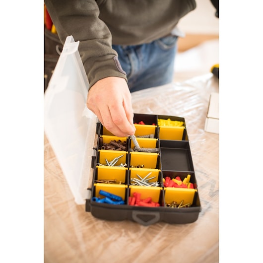 STANLEY STST81680-1 organizer box with yellow compartments, assorted screws and plugs, top view.