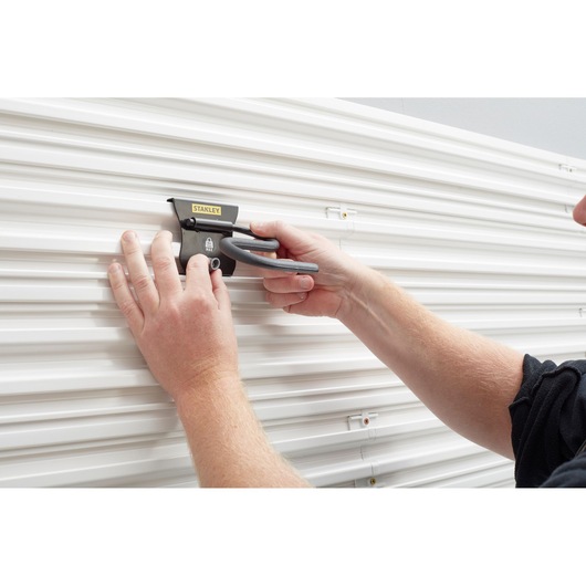 Stanley STST82605-1 wall mount hook in use for tool storage on white panel, close-up angle.