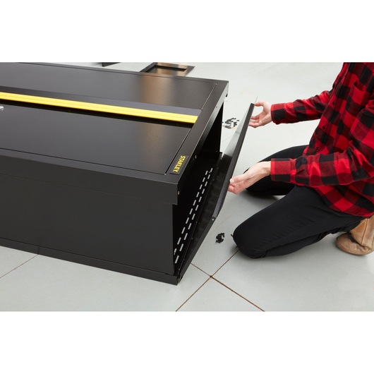 Photo of STANLEY STST97957-1 black metal storage cabinet with open front panel during assembly, workshop setting.