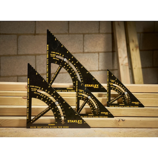 Photo of STANLEY STHT46055-0 black metric rafter squares with yellow markings, shown on wooden planks.